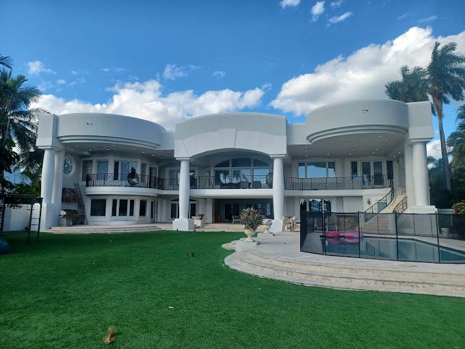 A large white house with a pool in the backyard
