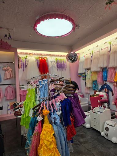 A bunch of dresses are hanging on a rack in a store.