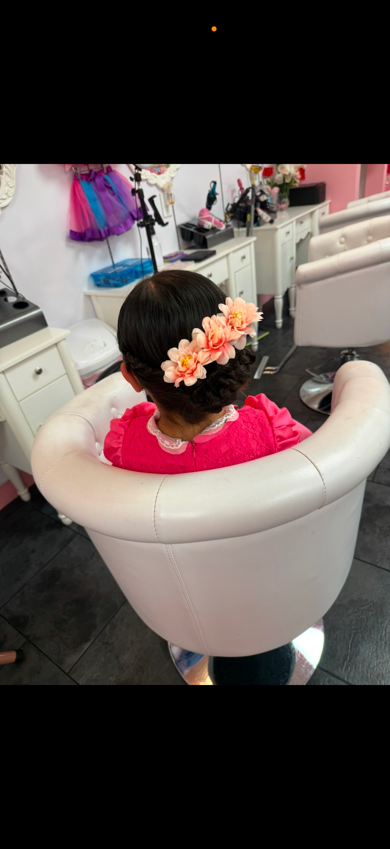 A woman is sitting in a chair with flowers in her hair.