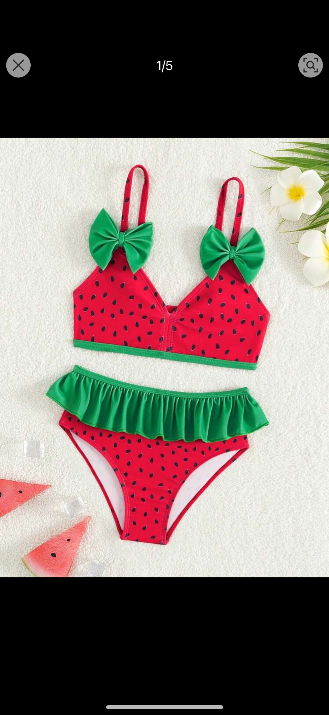 A little girl is wearing a watermelon bikini.