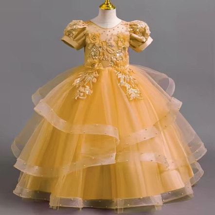 A little girl is wearing a yellow dress on a mannequin.