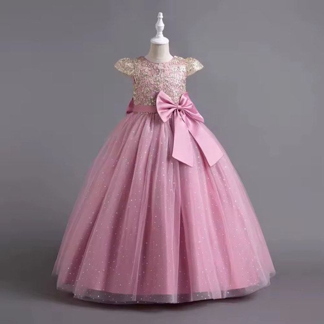 A pink dress with a bow on the back is on a mannequin.