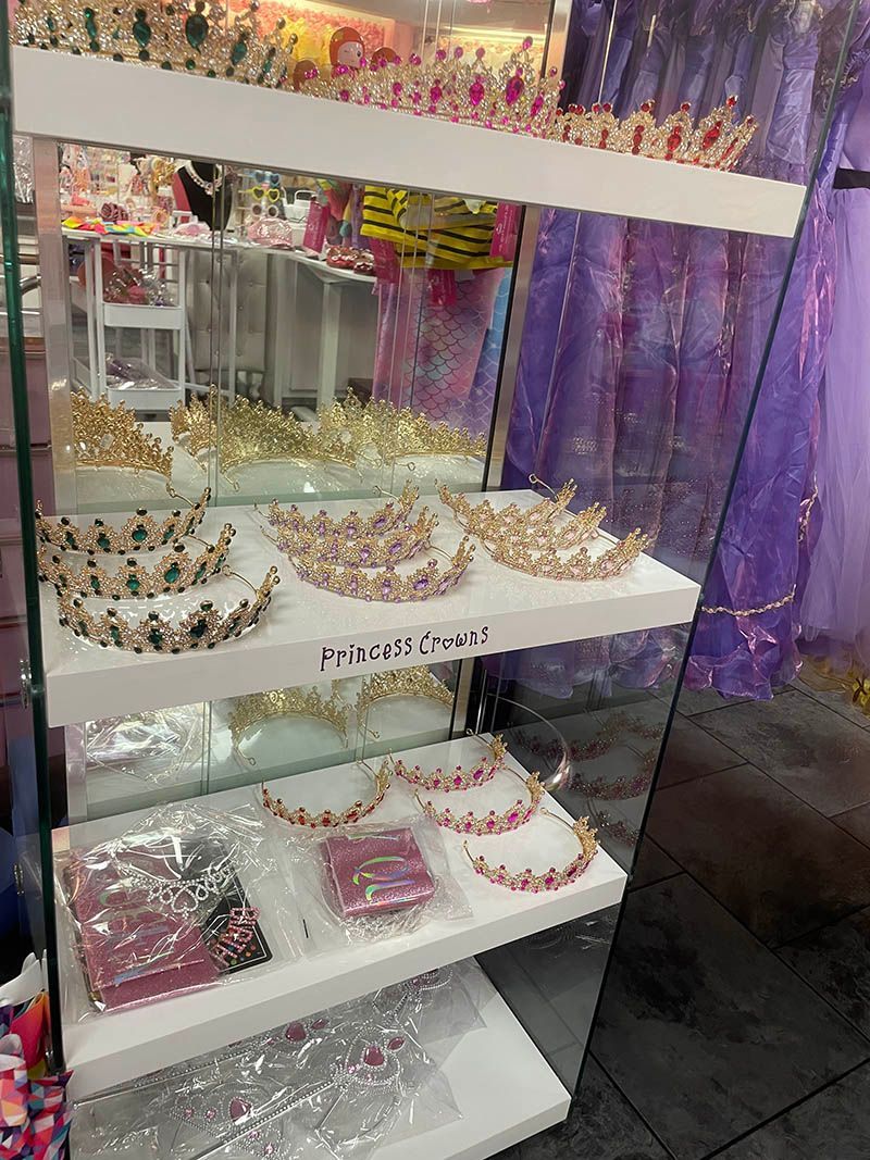 A display case filled with lots of tiaras and necklaces in a store.