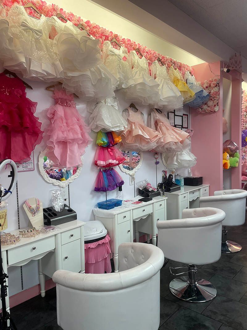 There are many dresses hanging on the wall in this room.