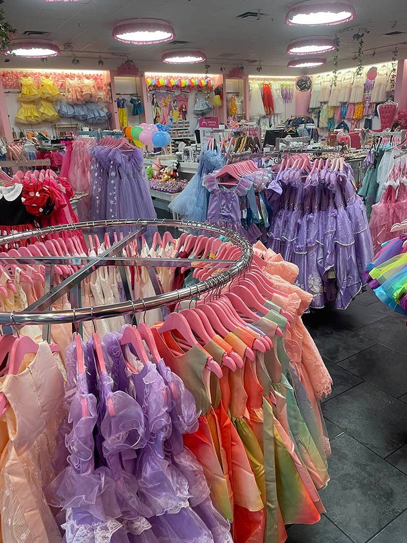 A store filled with lots of dresses hanging on racks.