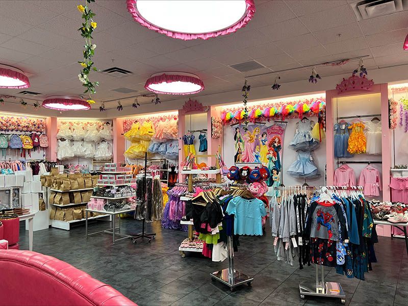 The inside of a children 's clothing store with a lot of clothes on display.