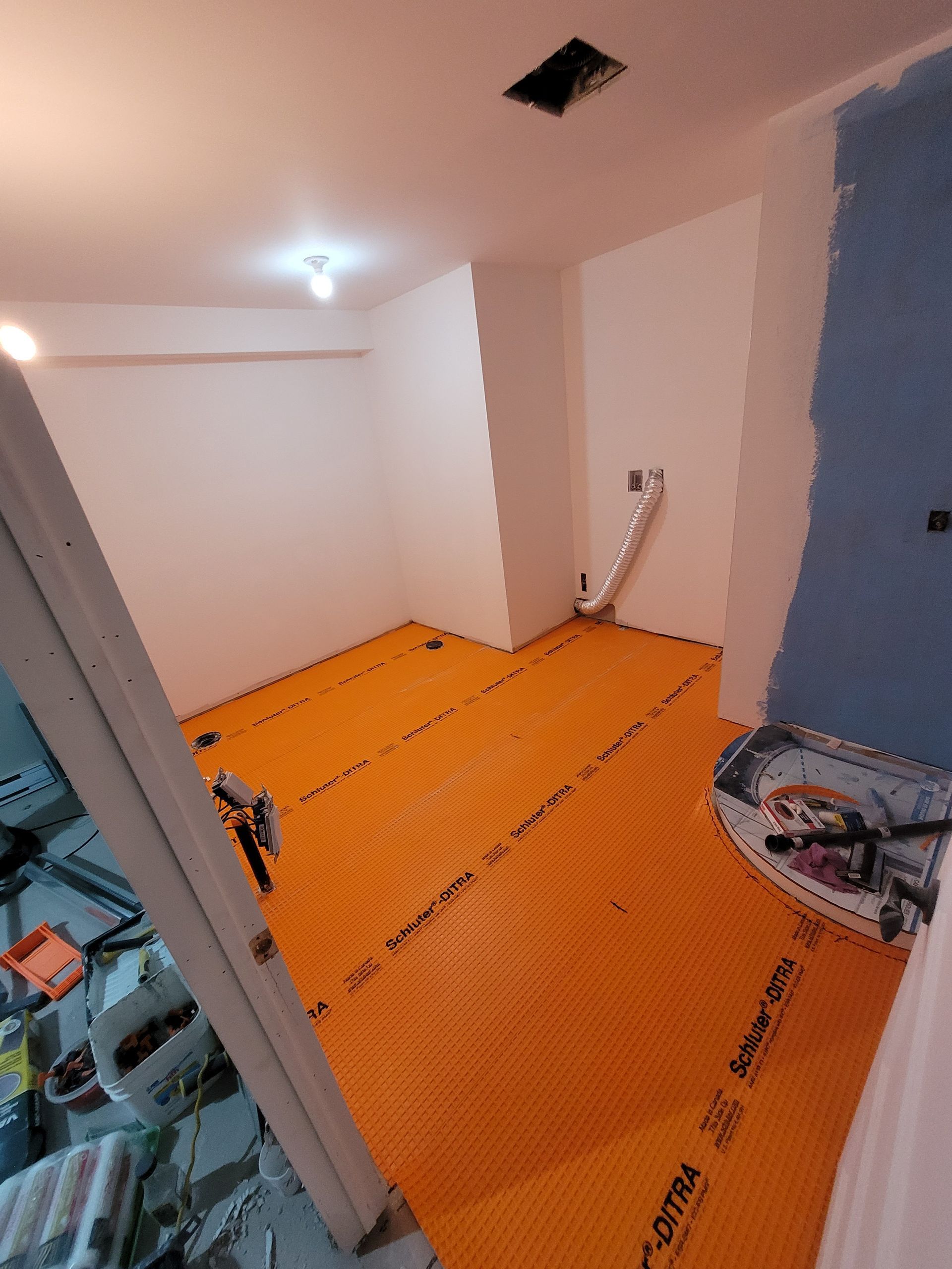 Une pièce avec des murs blancs et un sol orange.