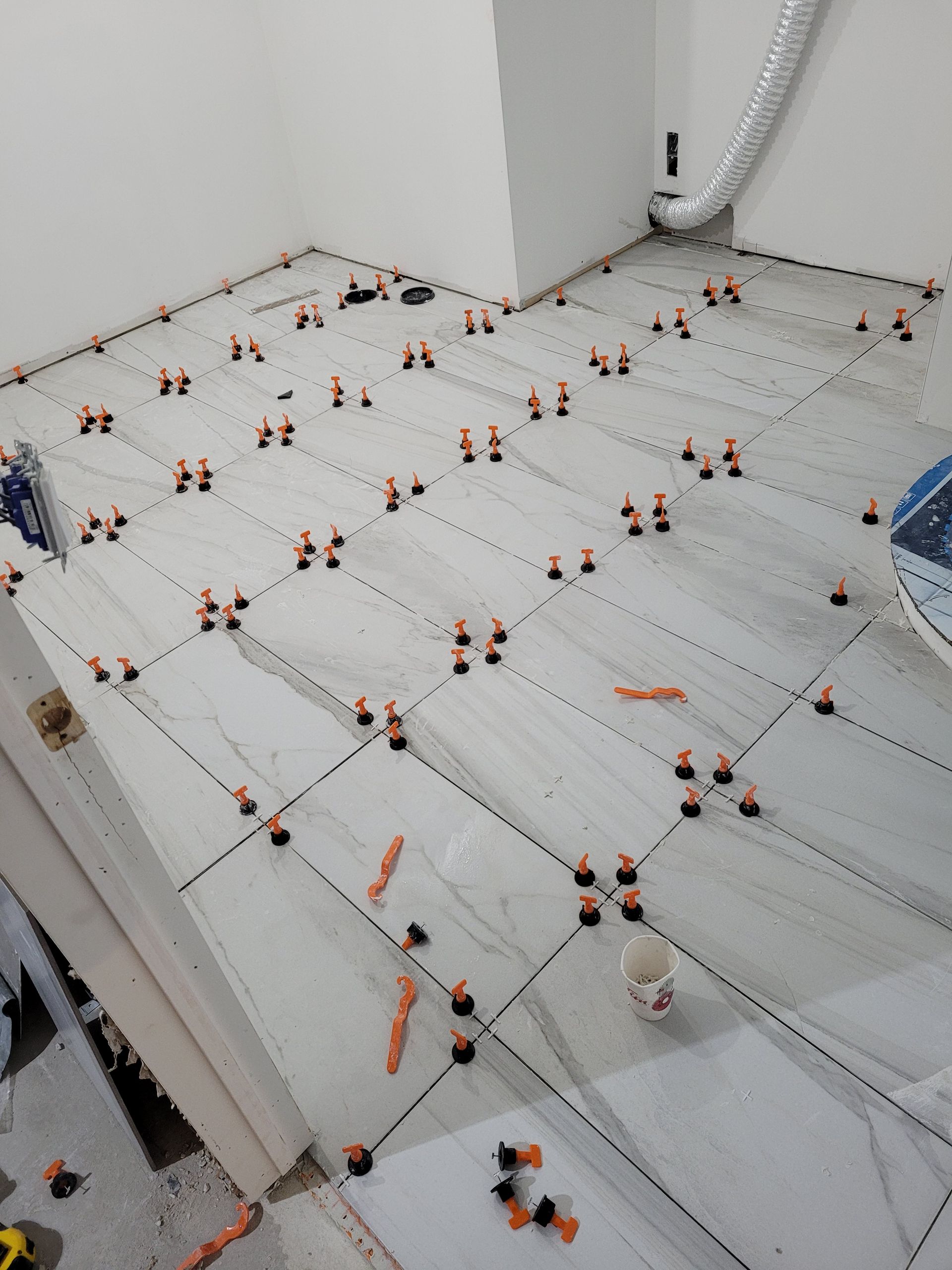 Un sol carrelé est en cours d'installation dans une pièce.