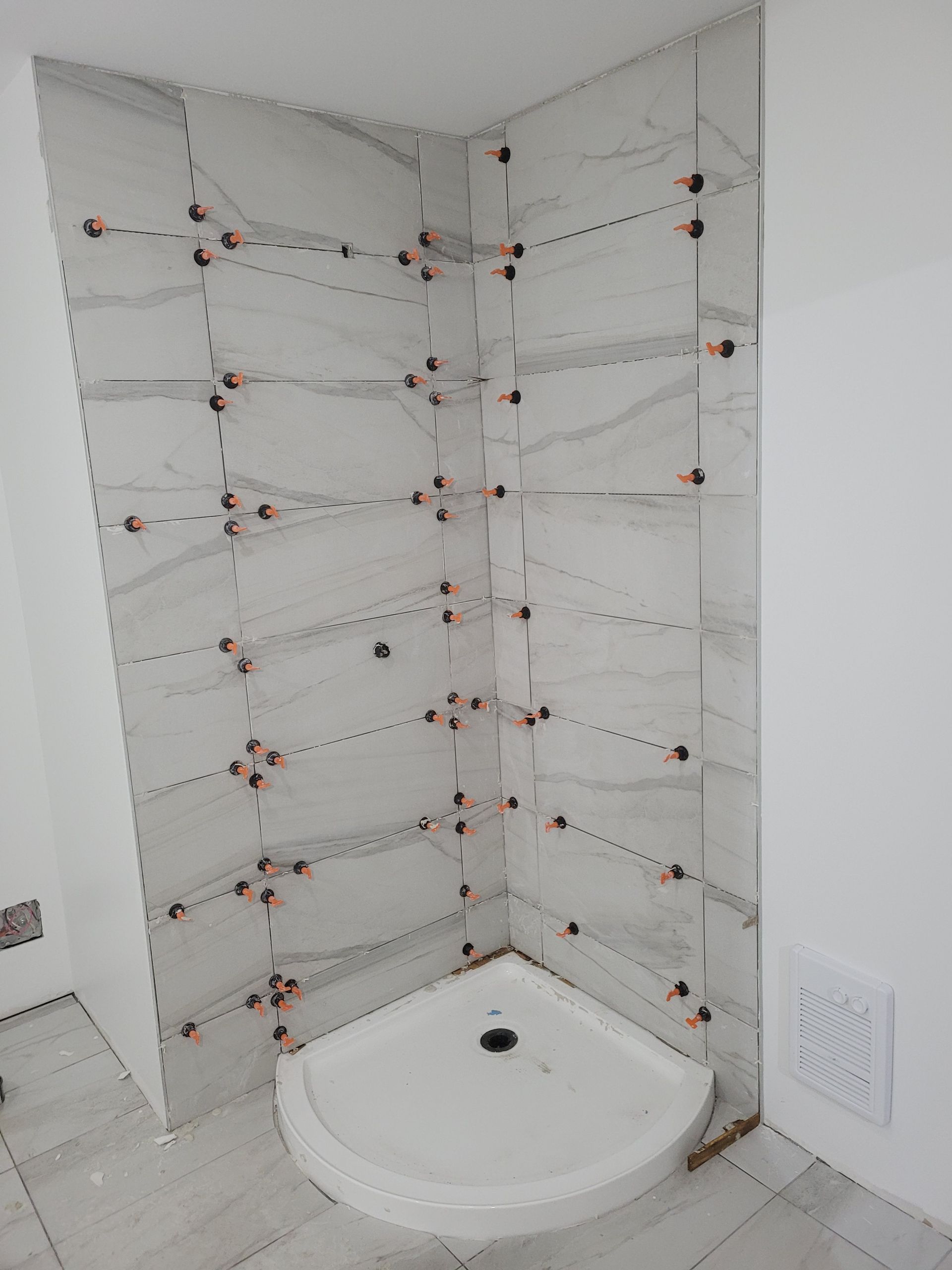 Une cabine de douche est en cours de construction dans une salle de bain.