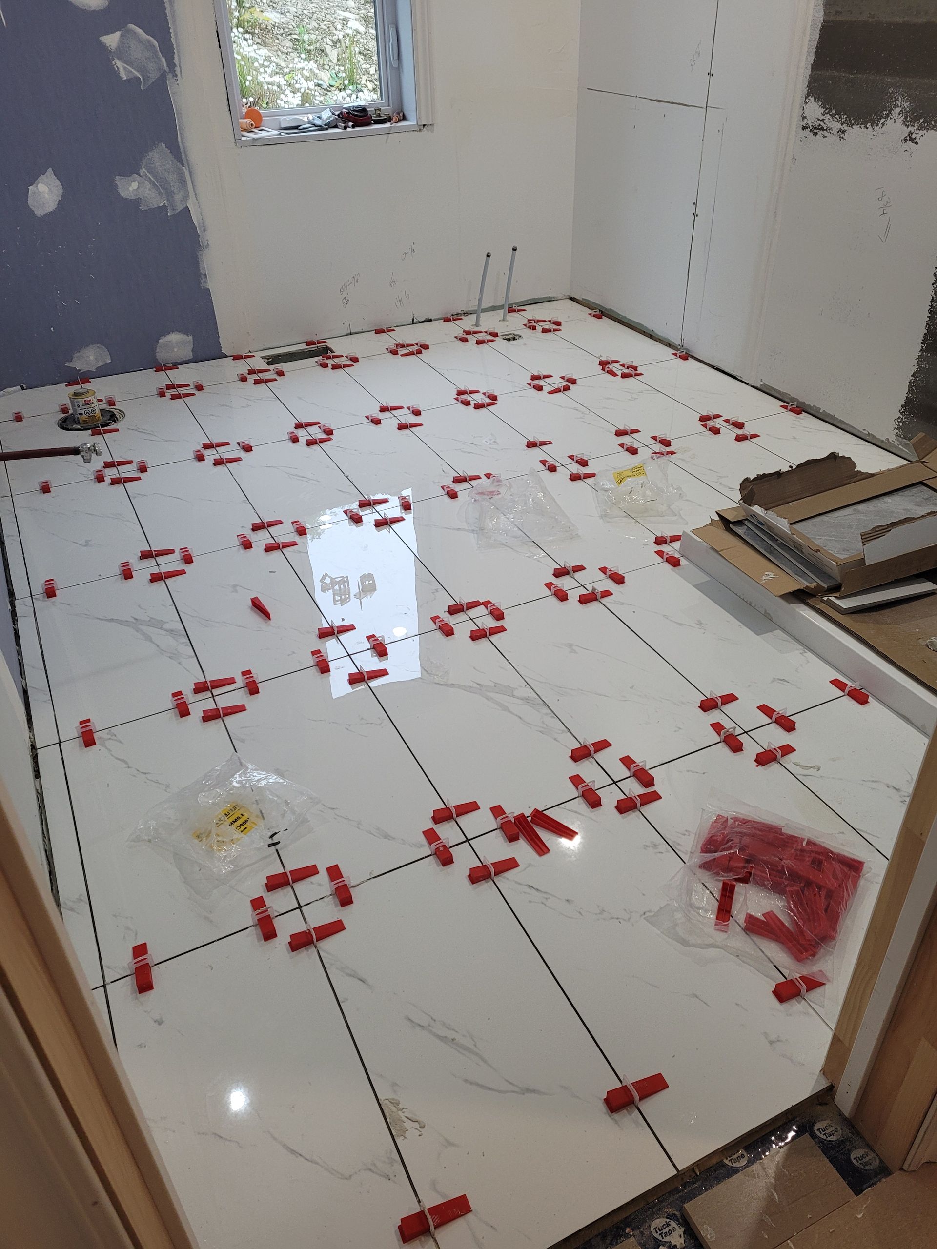 Un sol en carrelage blanc avec des entretoises rouges dessus