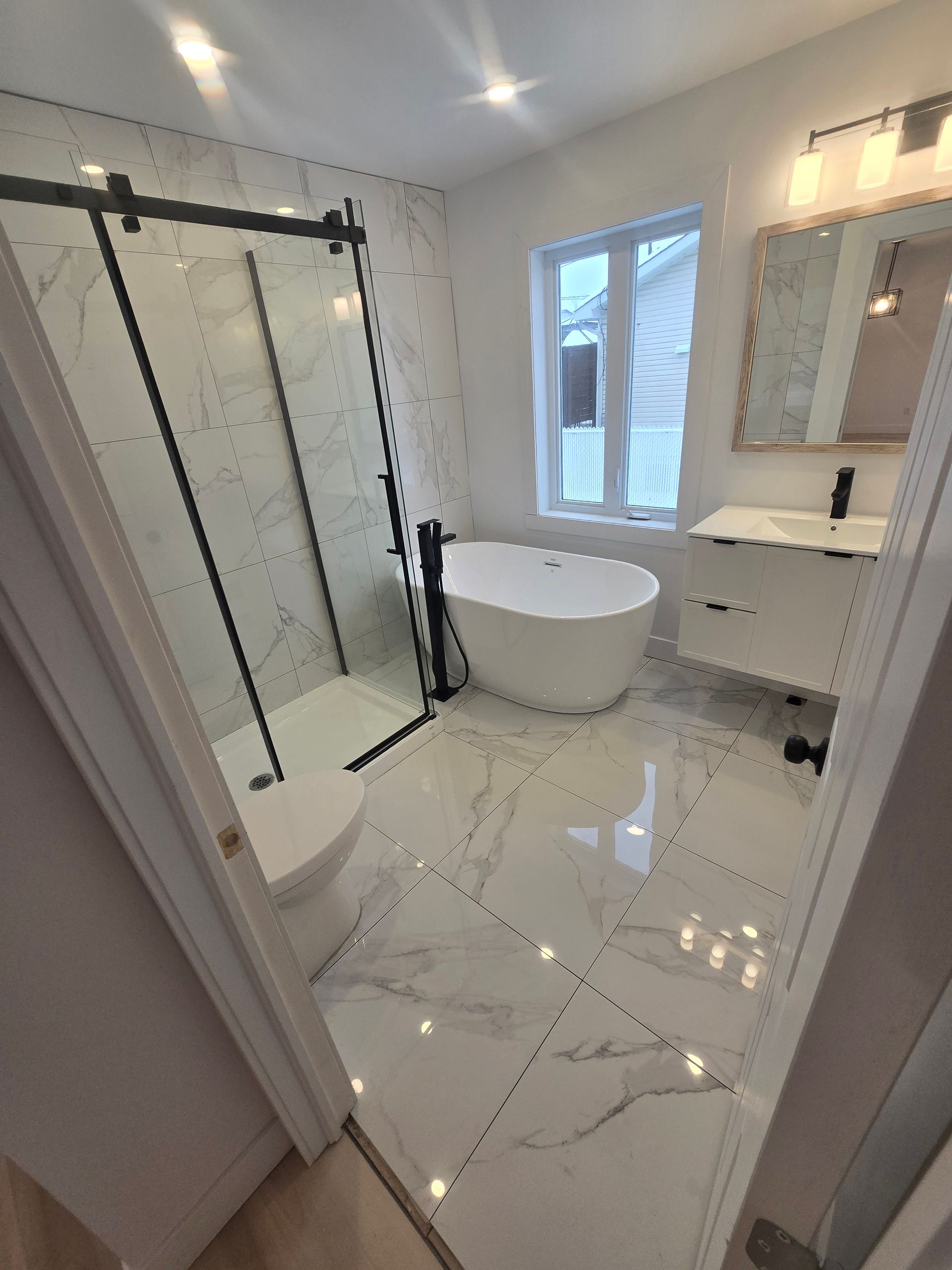 Une salle de bain avec baignoire, lavabo, WC et douche.