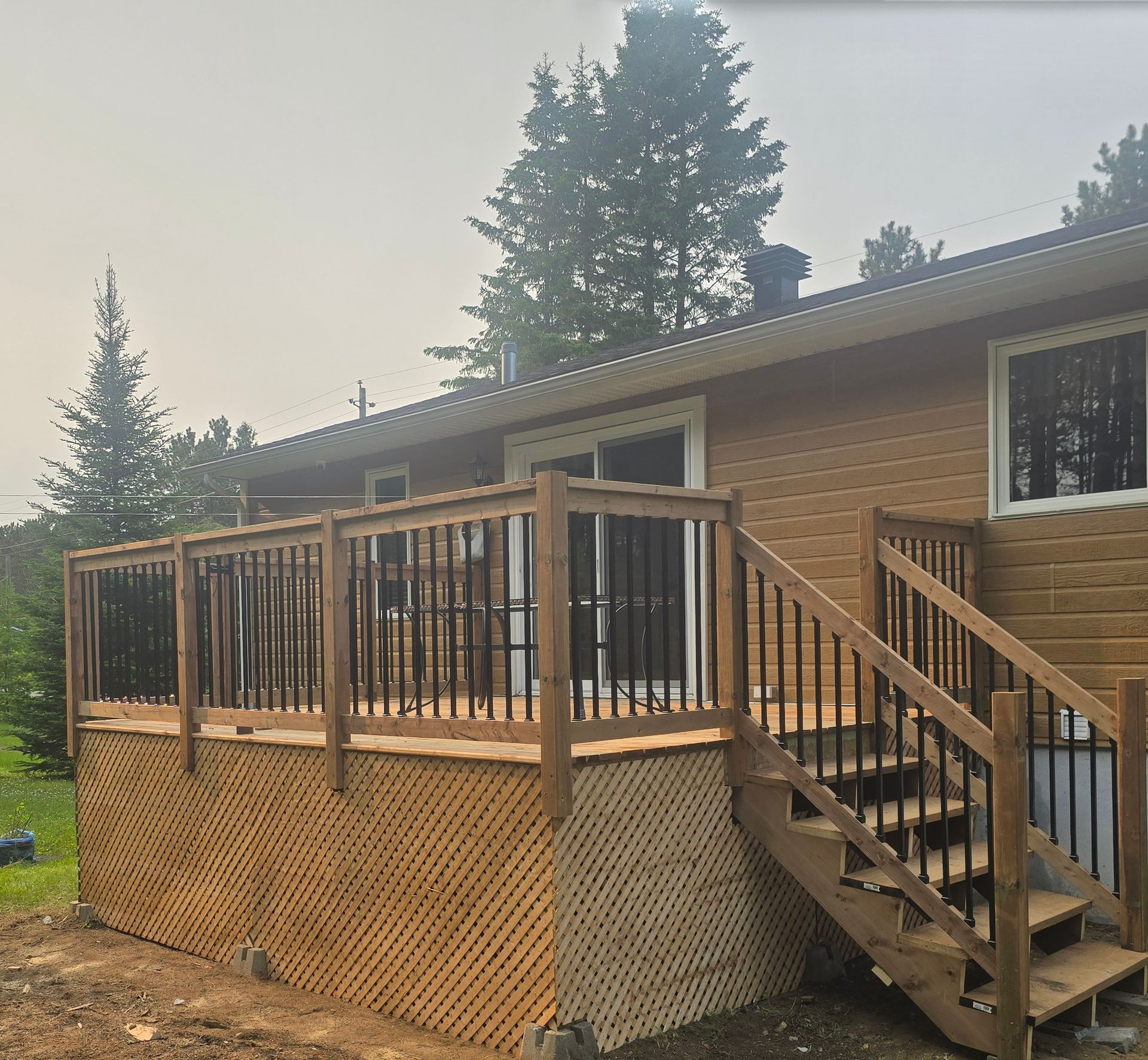 Une maison avec une terrasse en bois et des escaliers qui y mènent