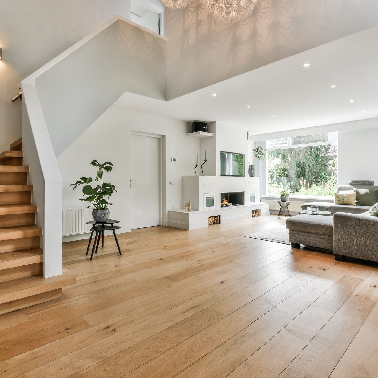 Un salon avec parquet et escaliers