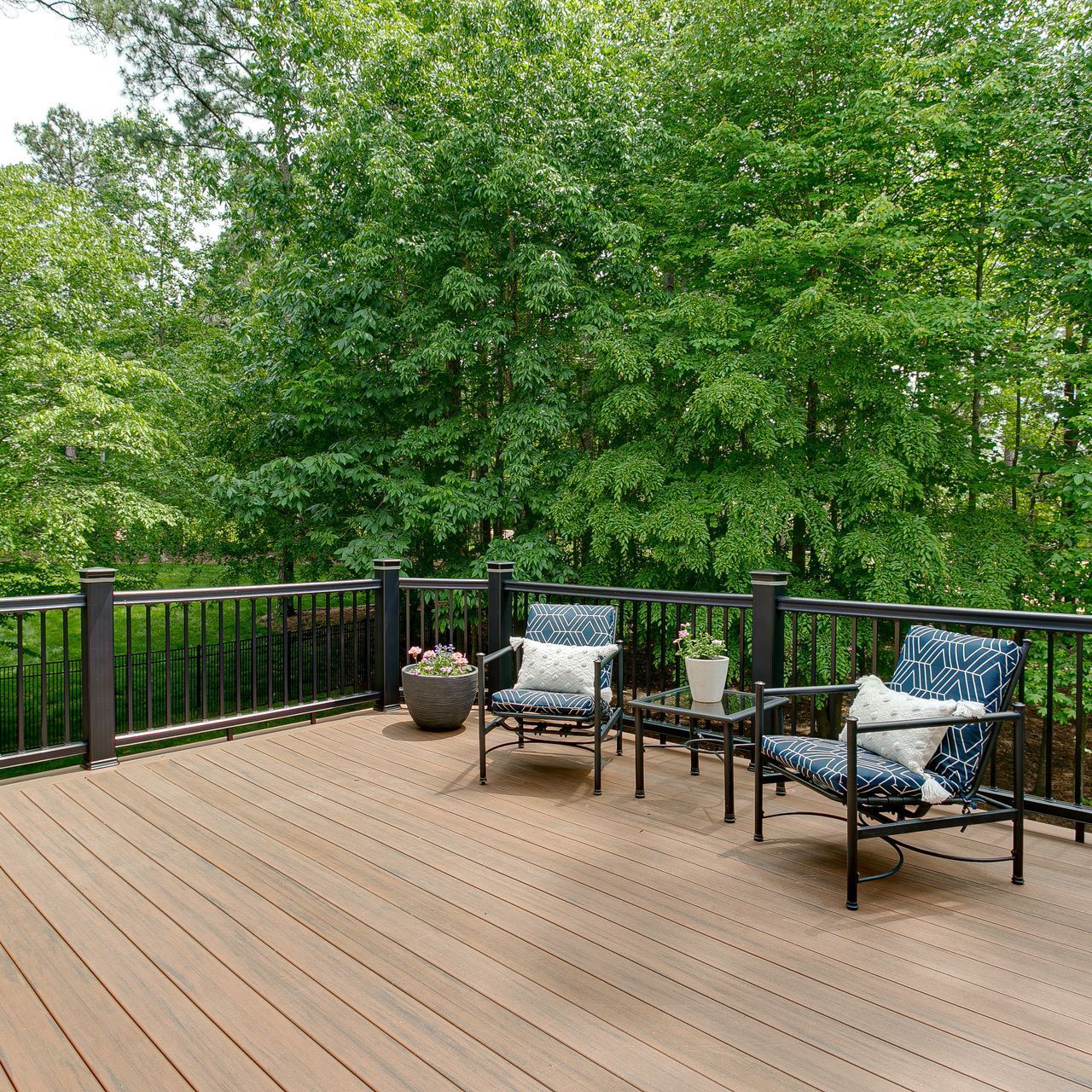 Une terrasse en bois avec deux chaises et une table