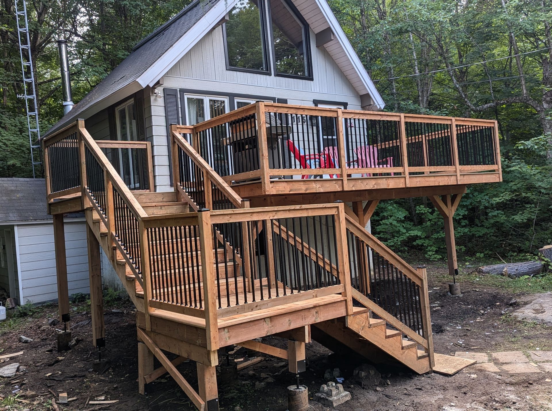 Une petite maison avec une grande terrasse en bois et des escaliers.