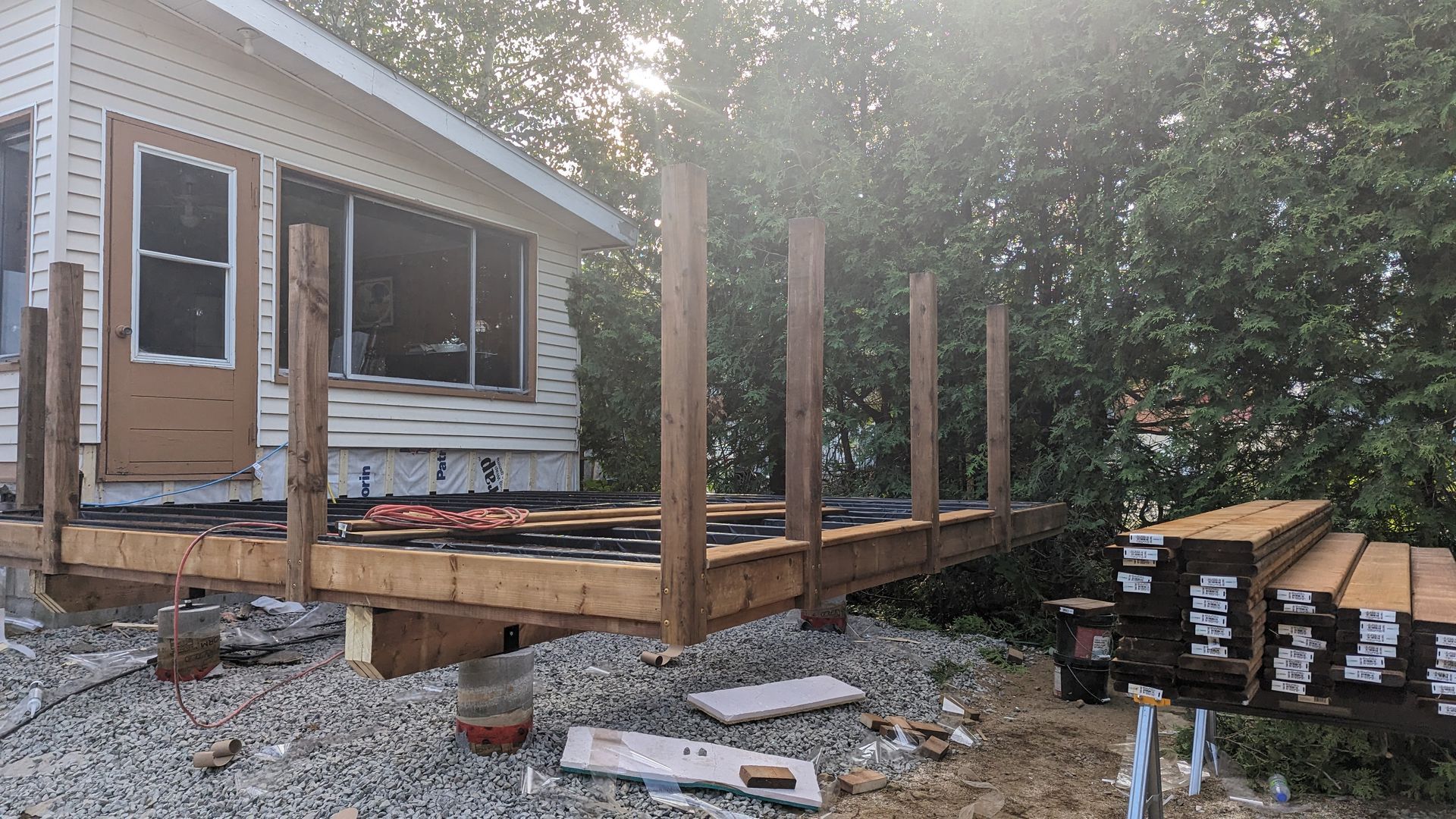 Une terrasse en bois est en cours de construction devant une maison.