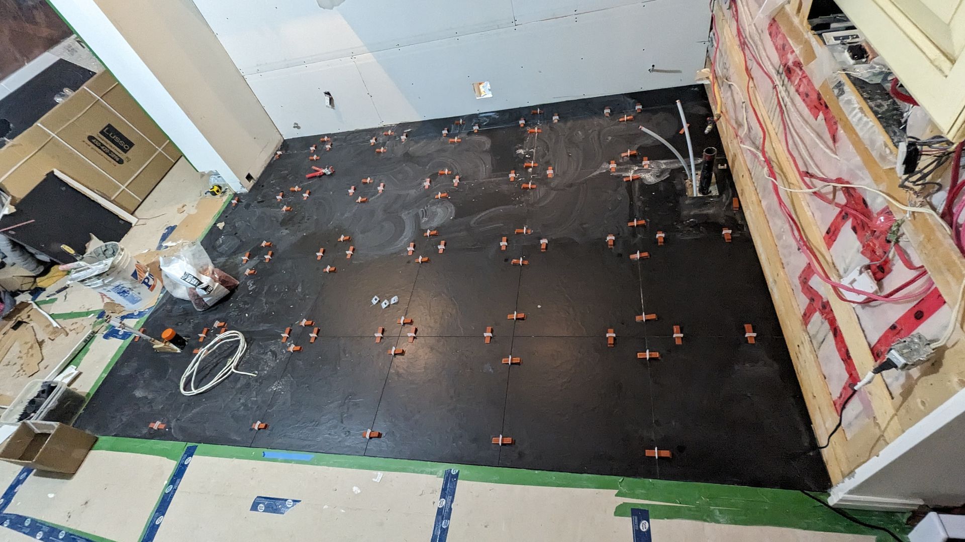 Un grand carrelage noir est en cours d'installation dans une cuisine.