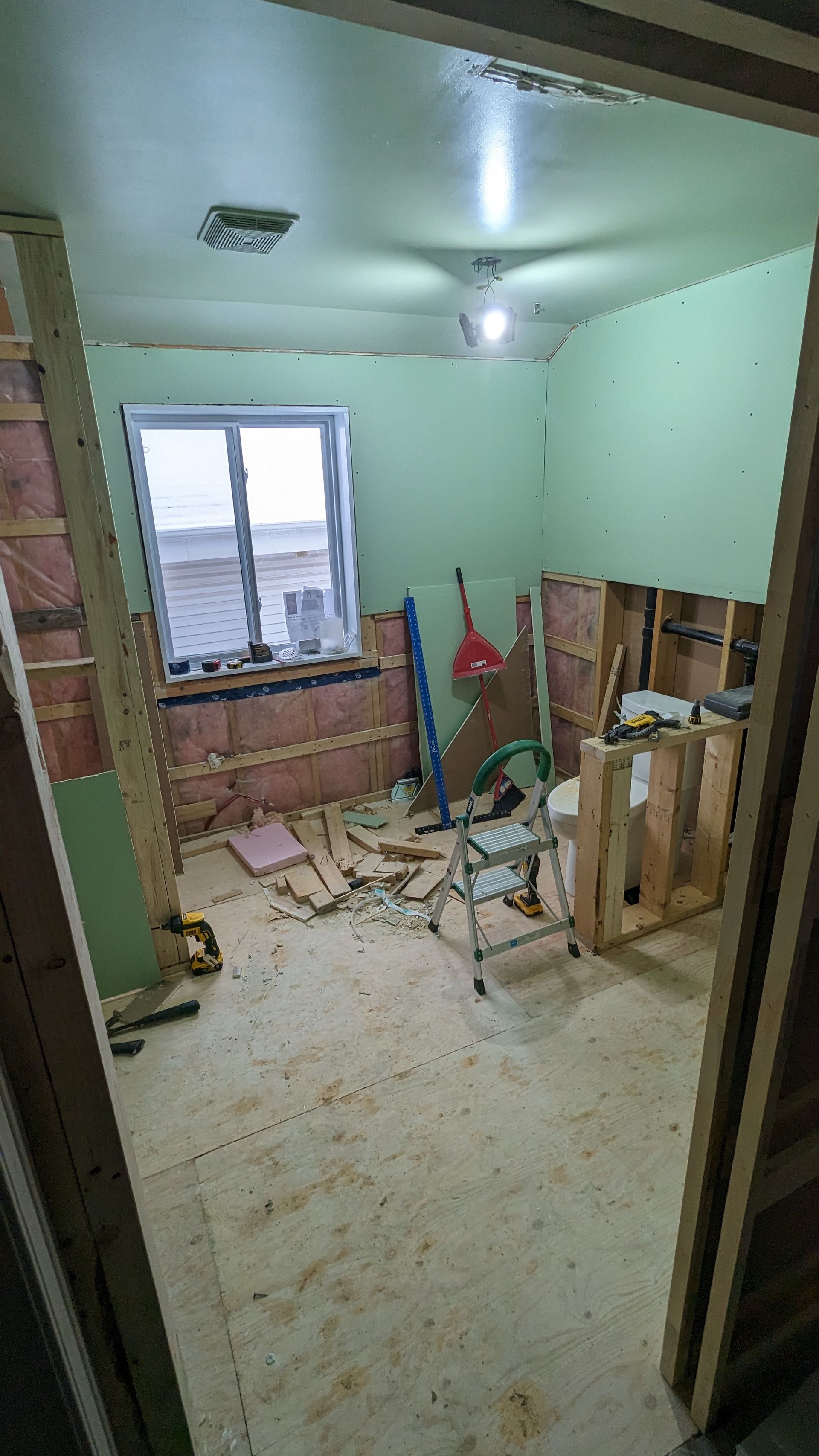 Une pièce avec une fenêtre et une échelle est en cours de rénovation.