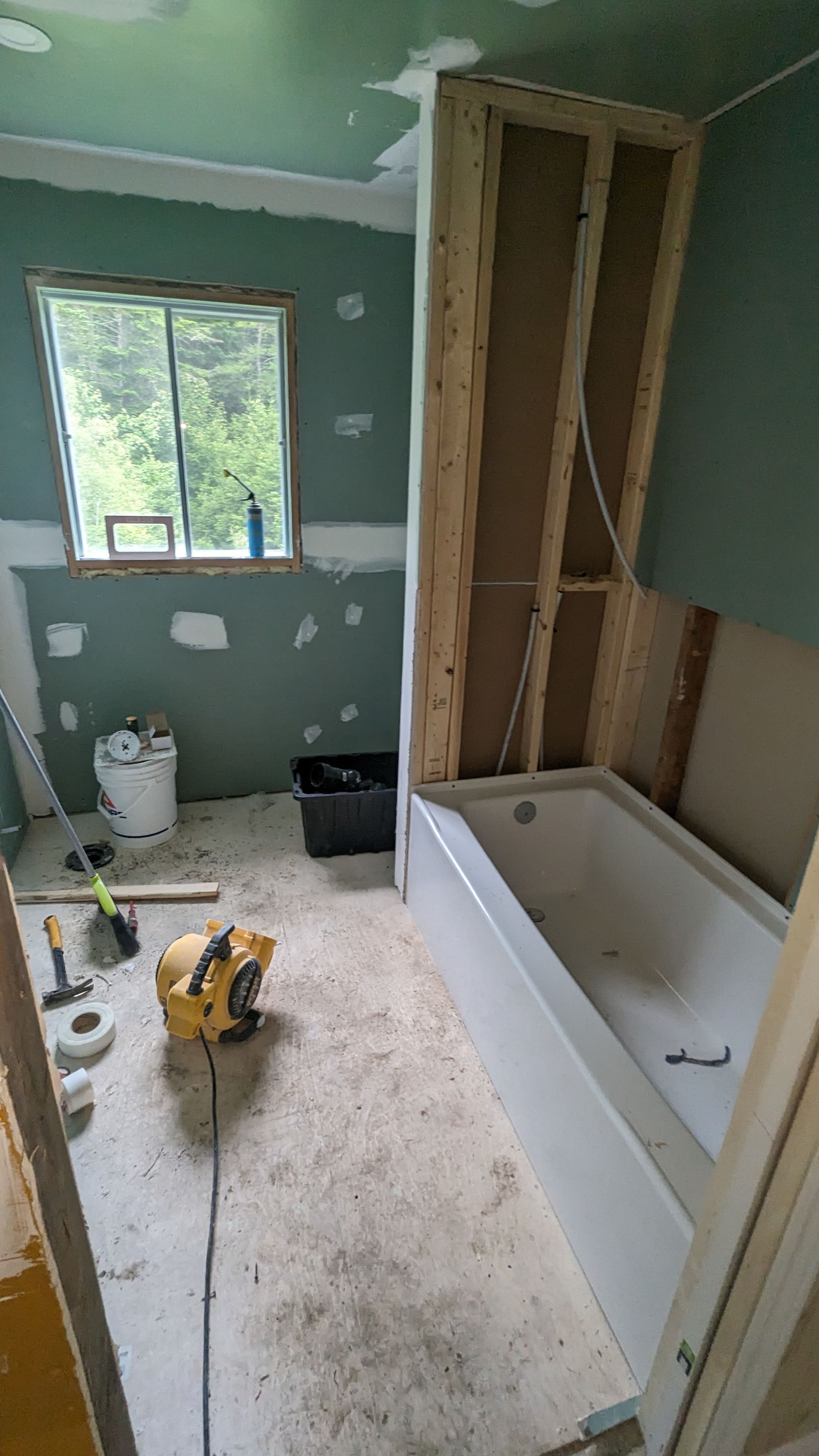 Une salle de bain en construction avec une baignoire et une fenêtre.