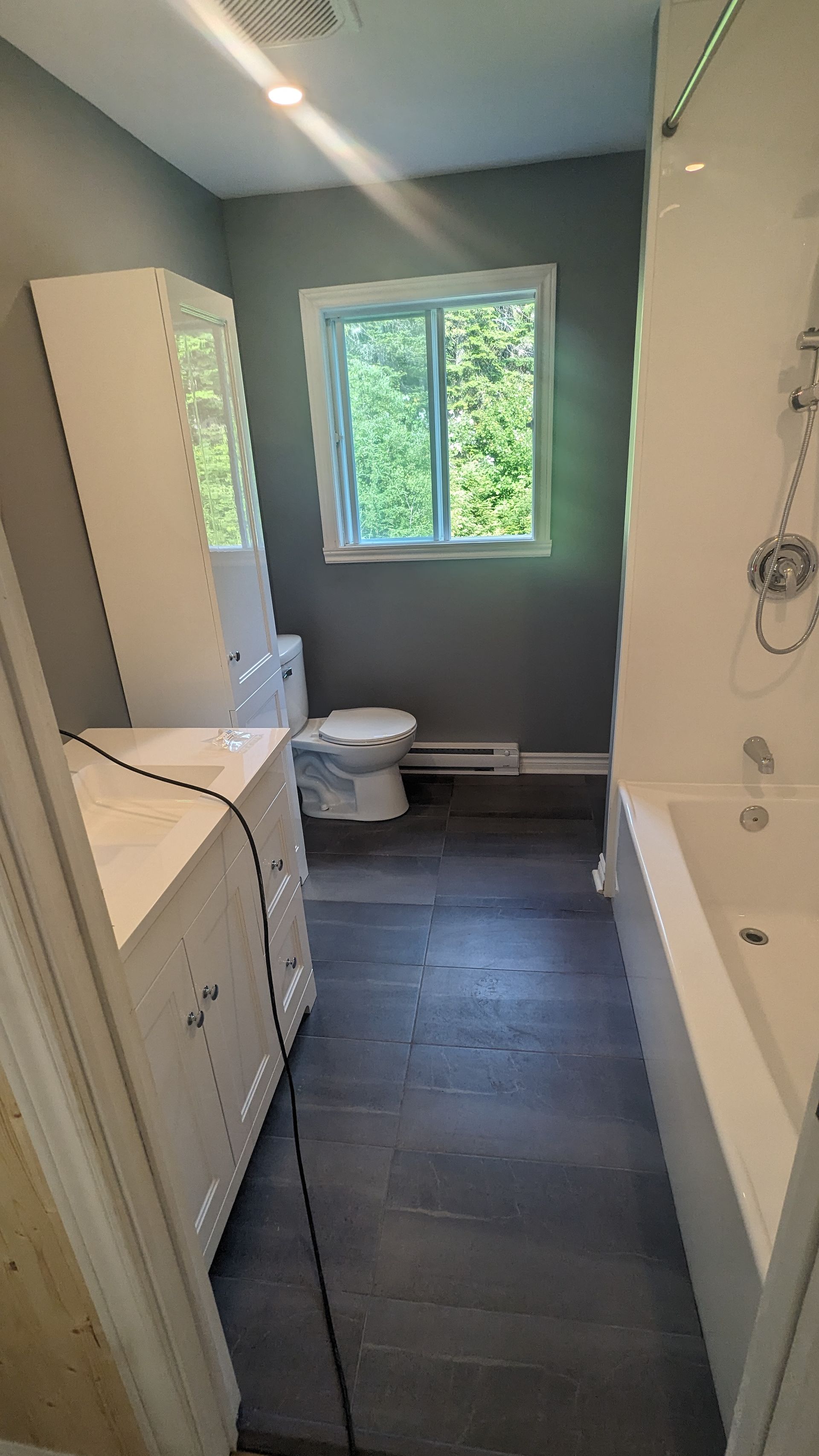 Une salle de bain avec WC, lavabo et baignoire.