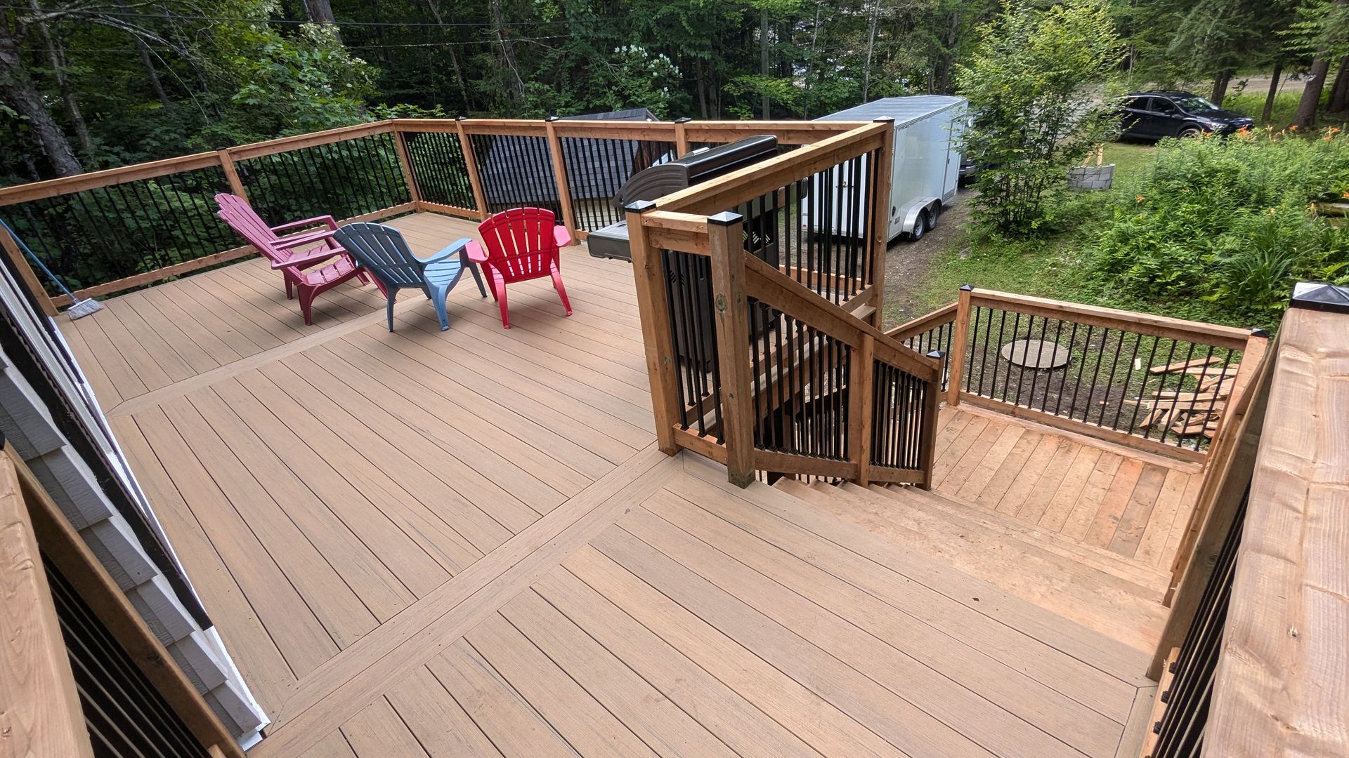 Une terrasse en bois avec des escaliers et des chaises dessus
