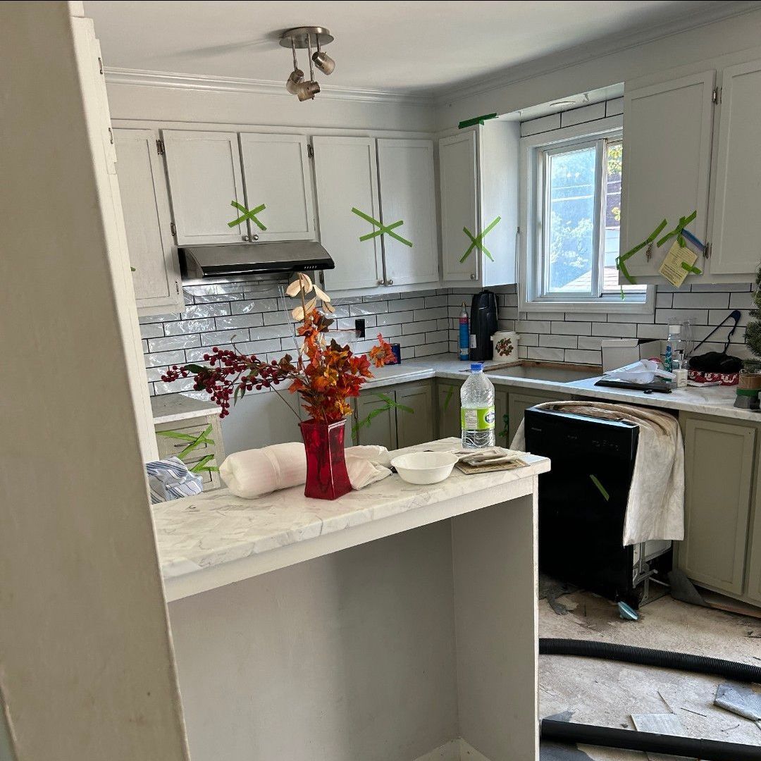 Une cuisine avec un vase de fleurs sur le comptoir.