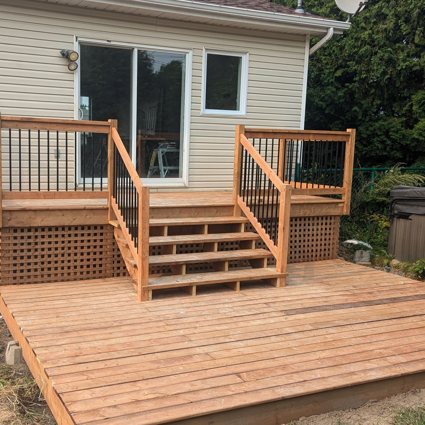 Une terrasse en bois avec des escaliers devant une maison