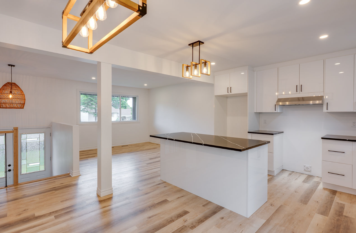 Une cuisine vide avec un grand îlot au milieu de la pièce.