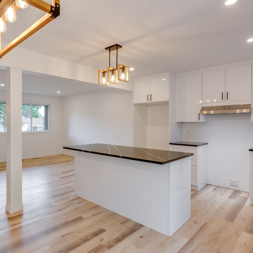 An empty kitchen with white cabinets and a large island