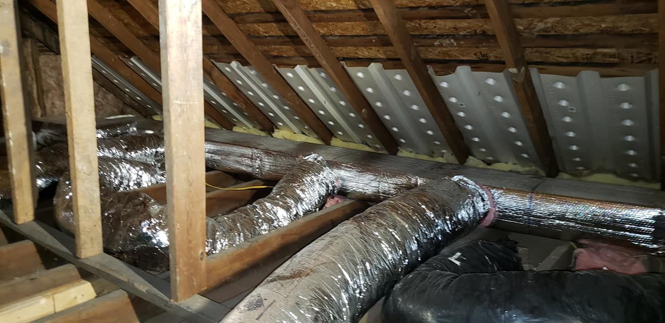There are a lot of pipes in the attic of a house.