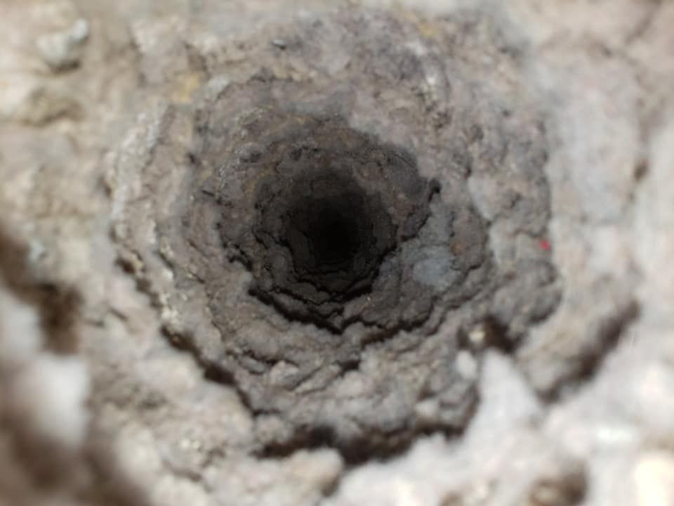 A close up of a hole in a concrete wall.
