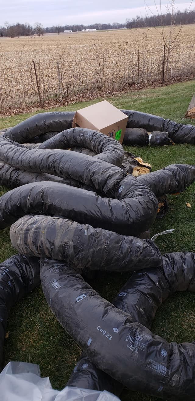 A bunch of black bags sitting on top of a lush green field.