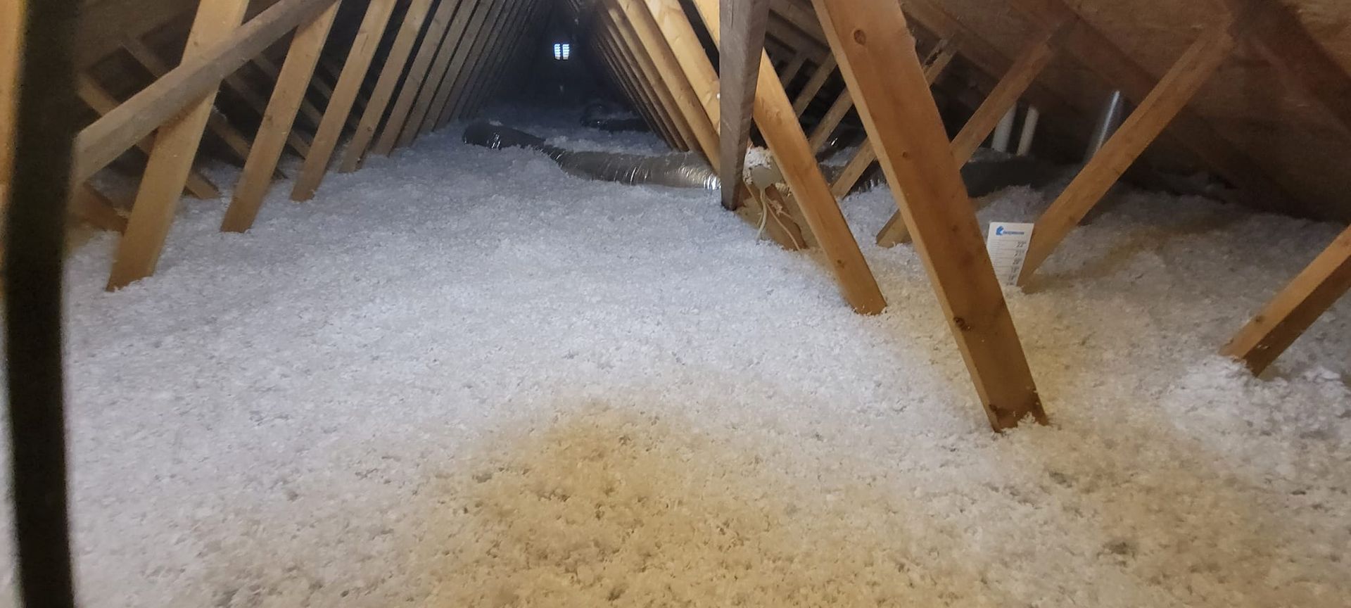 There is a lot of insulation in the attic of a house.