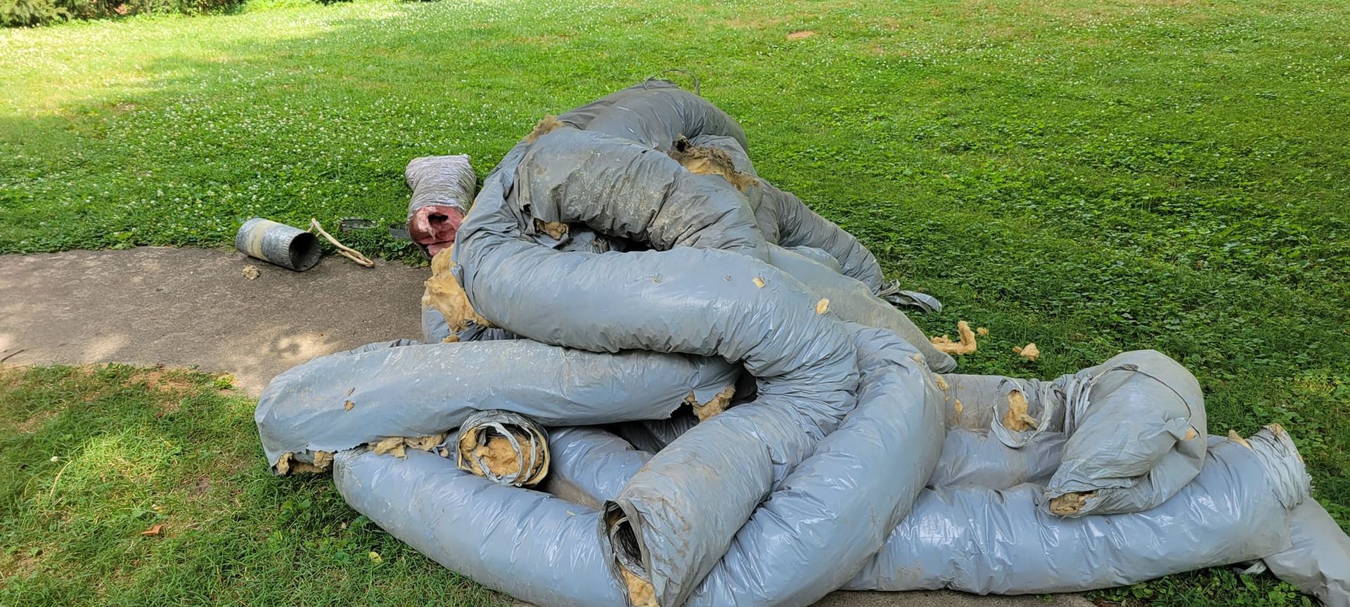 A pile of pipes sitting on top of a lush green field.