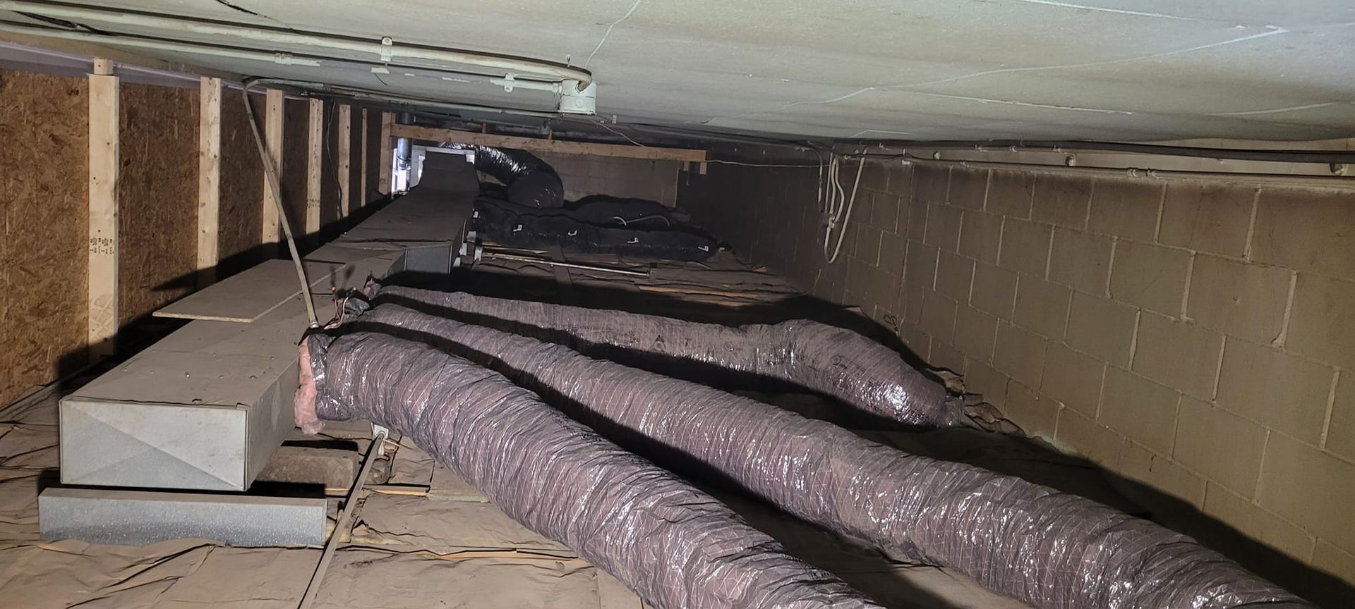 A bunch of ducts are hanging from the ceiling of a building.