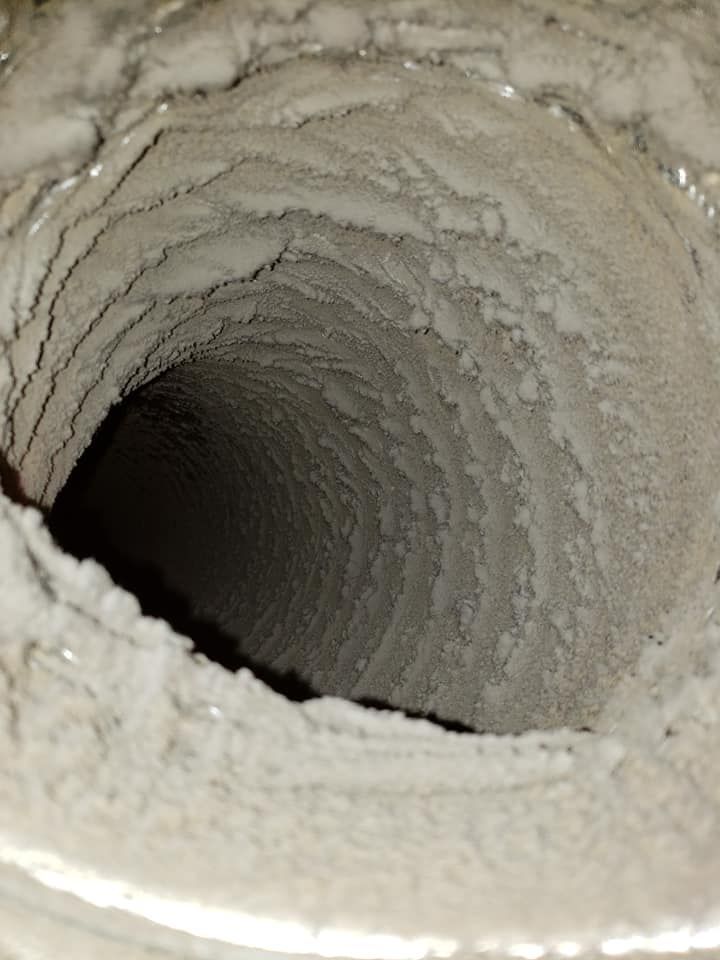A close up of a dirty air duct with a hole in the middle.