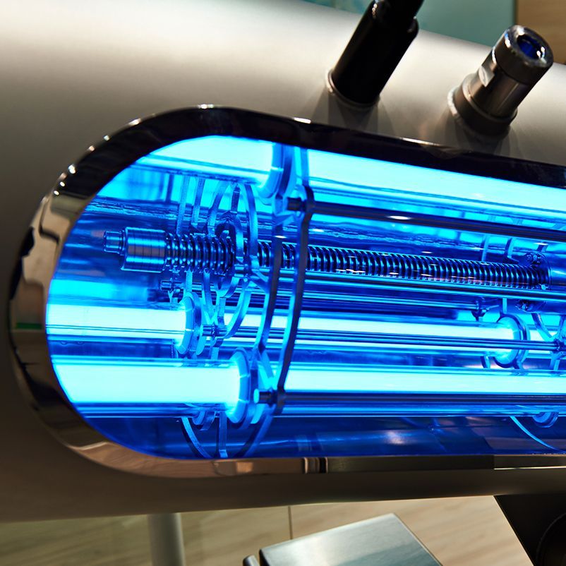 A blue light is shining on a metal pipe