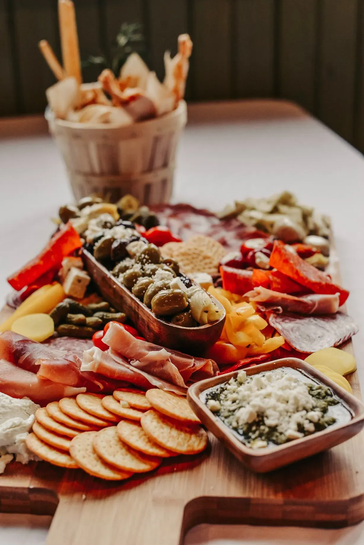 charcuterie-centerpiece-with-crackers-olive-oil-feta-dip-meats-cheeses-and-breadsticks