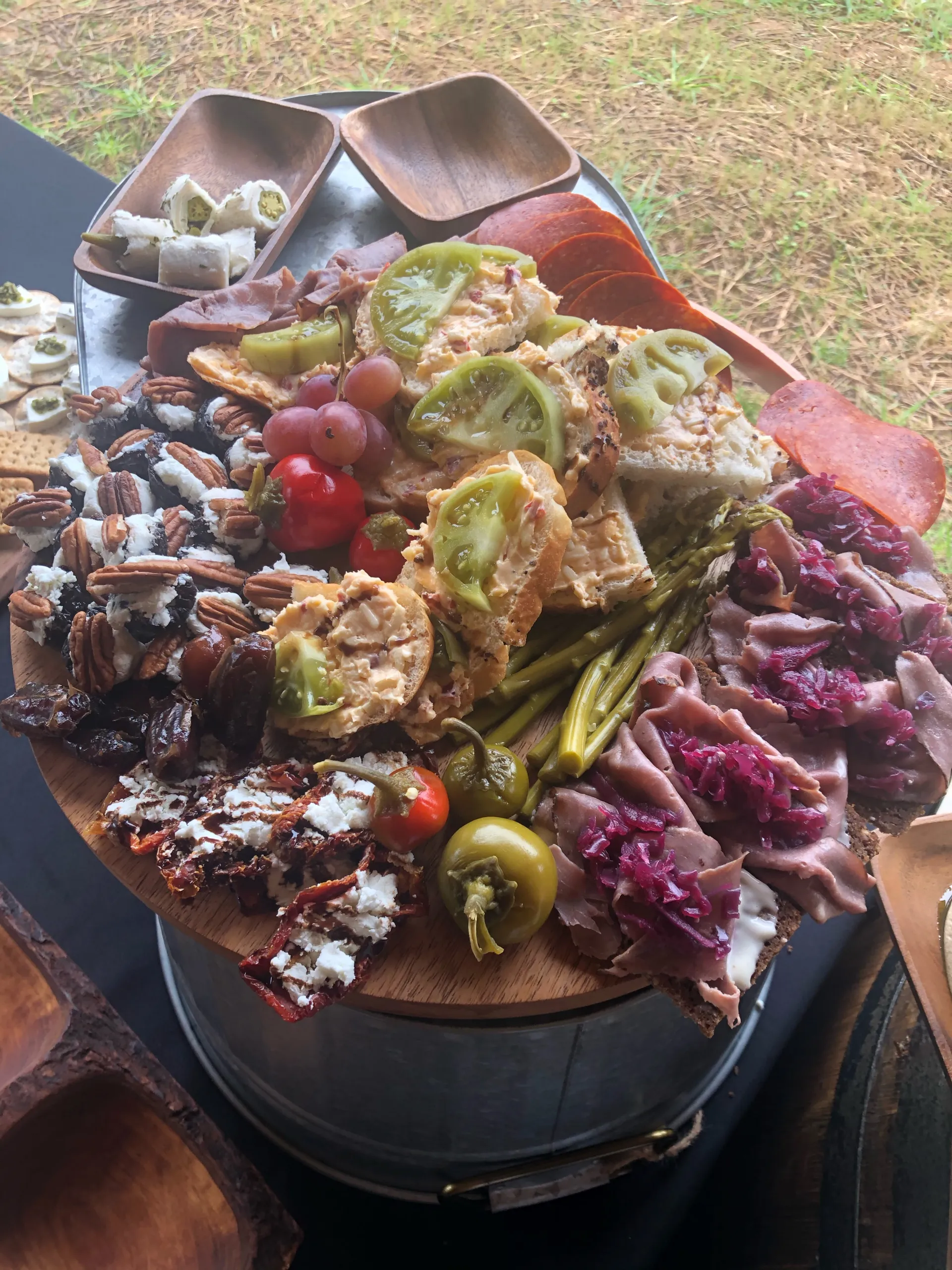 charcuterie-side-table-for-outdoor-event-with-fresh-green-tomatoes-homemade-okra-sadwiches-pickled