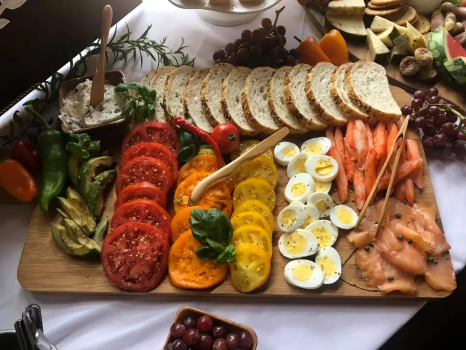 charcuterie-specialty-board-with-tomatoes-bread-eggs-smoked-salmon-avocados.