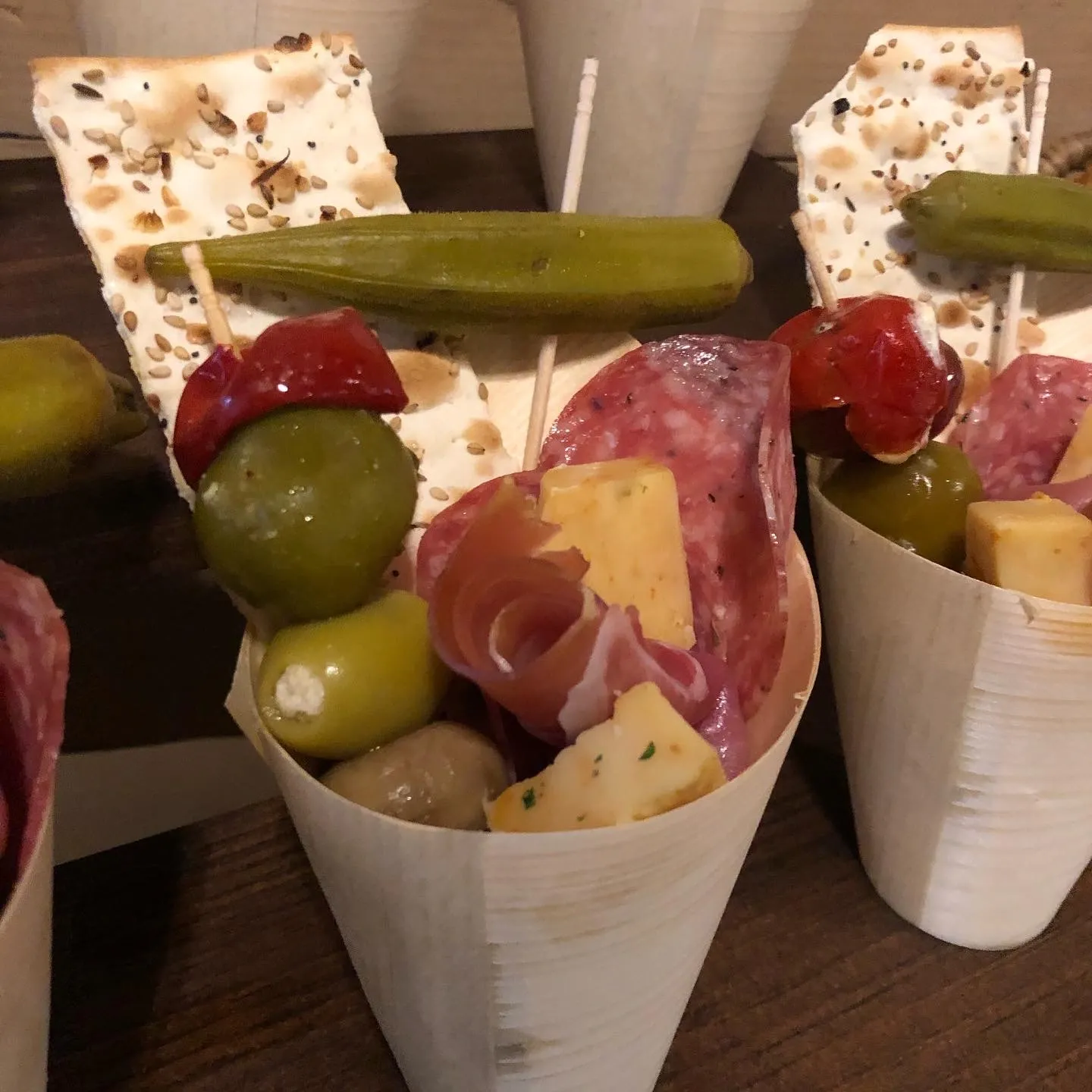 close-up-of-an-individual-characuterie-cups-with-fruit-cheese-crackers-veggies