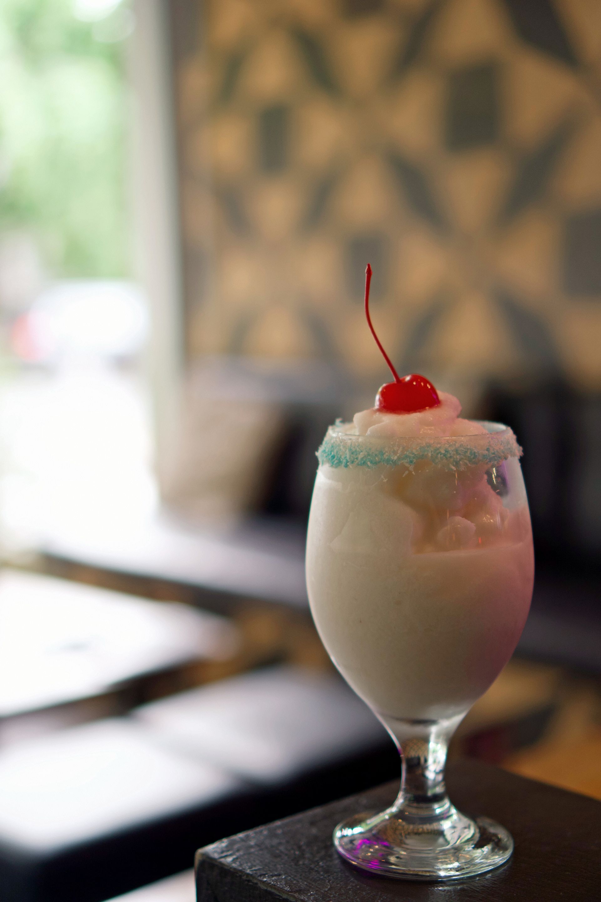 A Drink is Being Poured Into a Glass With a Pink Rim — Zachary's in Noosaville, QLD