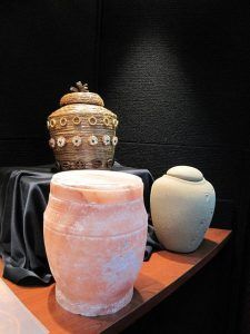 three urns are sitting on a wooden table .