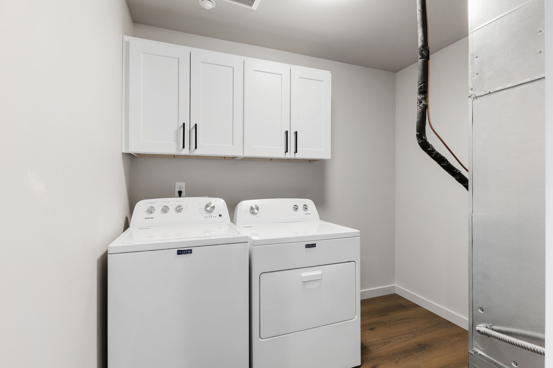Laundry room with white appliances and cabinets.