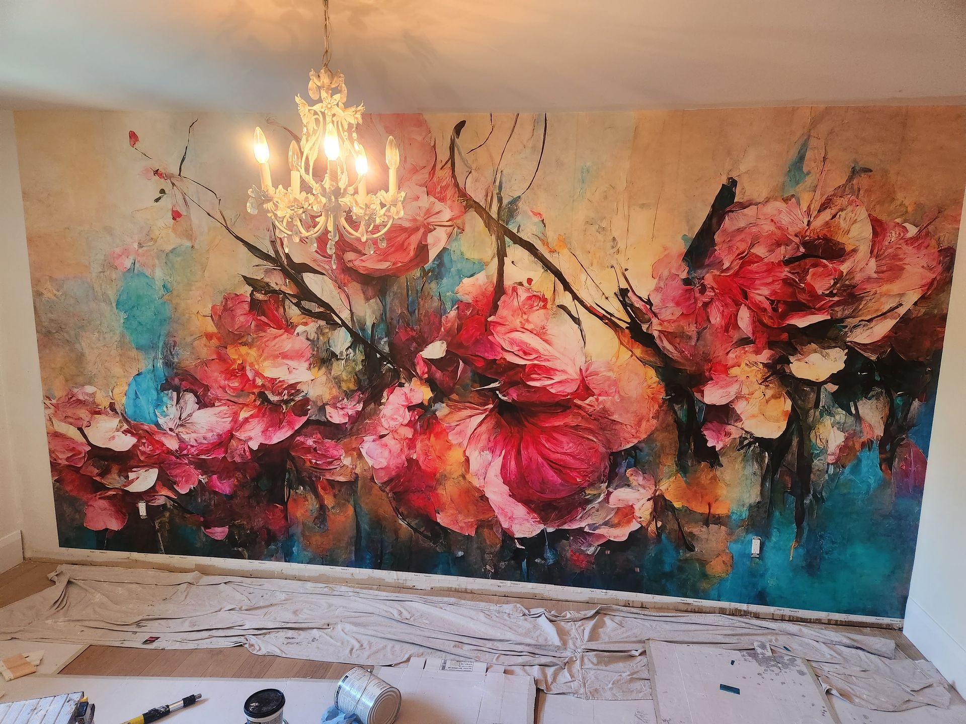 Large floral mural in shades of pink, orange, and blue, with a chandelier hanging above.
