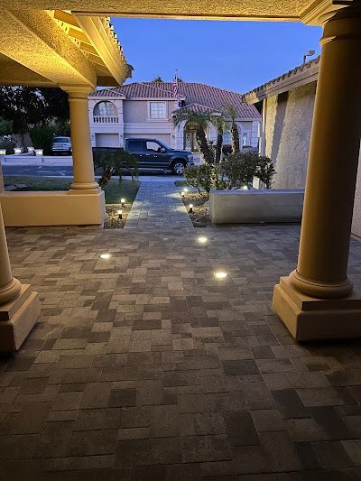 A patio with a lot of lights on it and a house in the background.