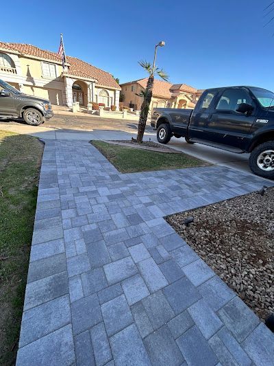 A black truck is parked on the side of the road next to a sidewalk.