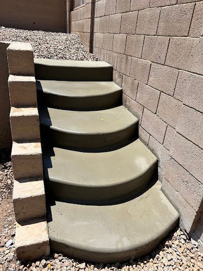 A set of concrete steps leading up to a brick wall.