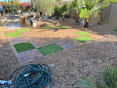 A hose is sitting on the ground in a backyard.