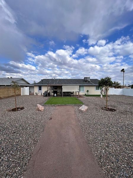 A house with a gravel driveway leading to it